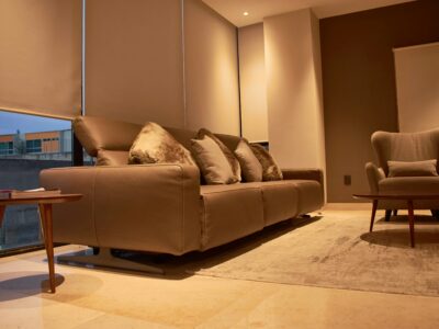 Modern living room with leather sofa, accent chair and neutral décor